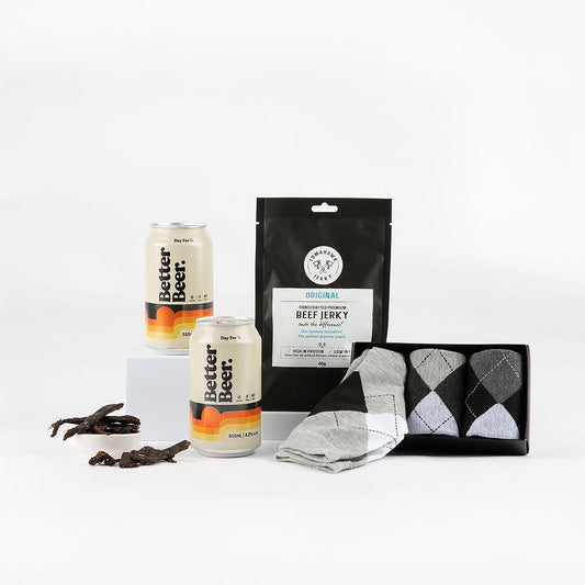 Collection of items including two cans of beer, beef jerky & socks on a white background