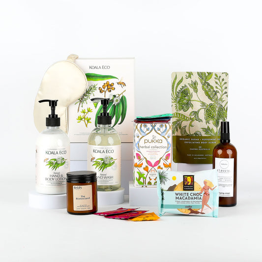 Collection of eco-friendly products including hand cream & wash, candle, and satin eye mask on a white background