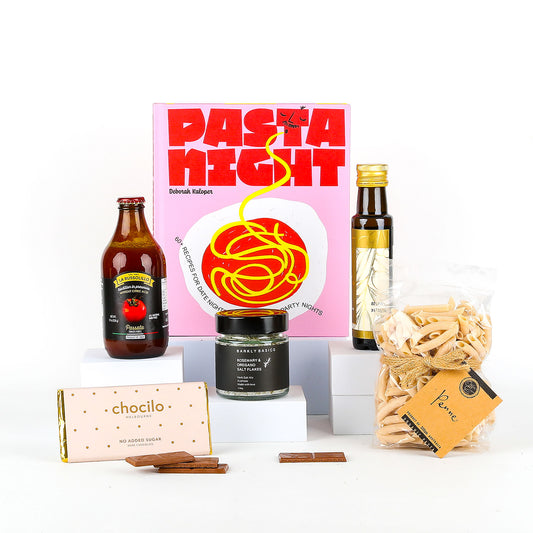 Gourmet gift set with pasta, sauce, and chocolate on a white background
