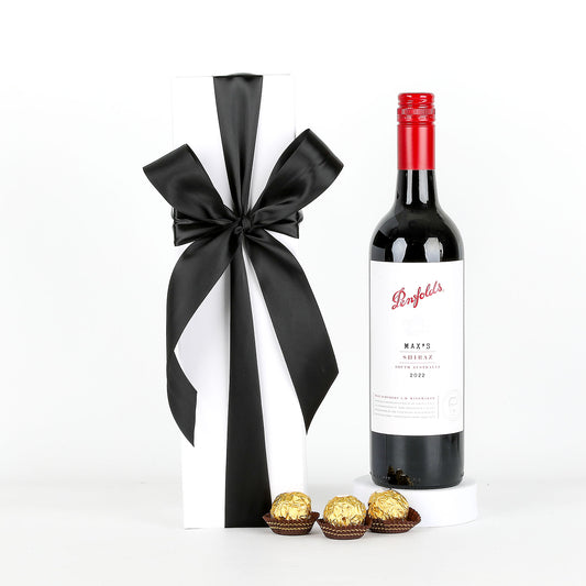 Penfolds wine bottle with a black ribbon and Ferrero Rocher chocolates on a white background