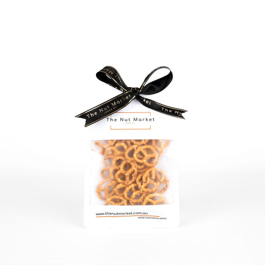 Packaged pretzels with a black ribbon and 'The Nut Market' branding on a white background