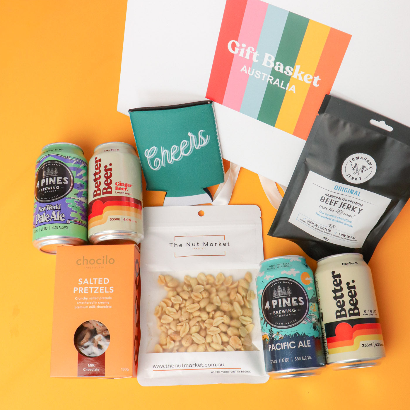 Gift basket with beer cans, snacks, and a card on an orange background
