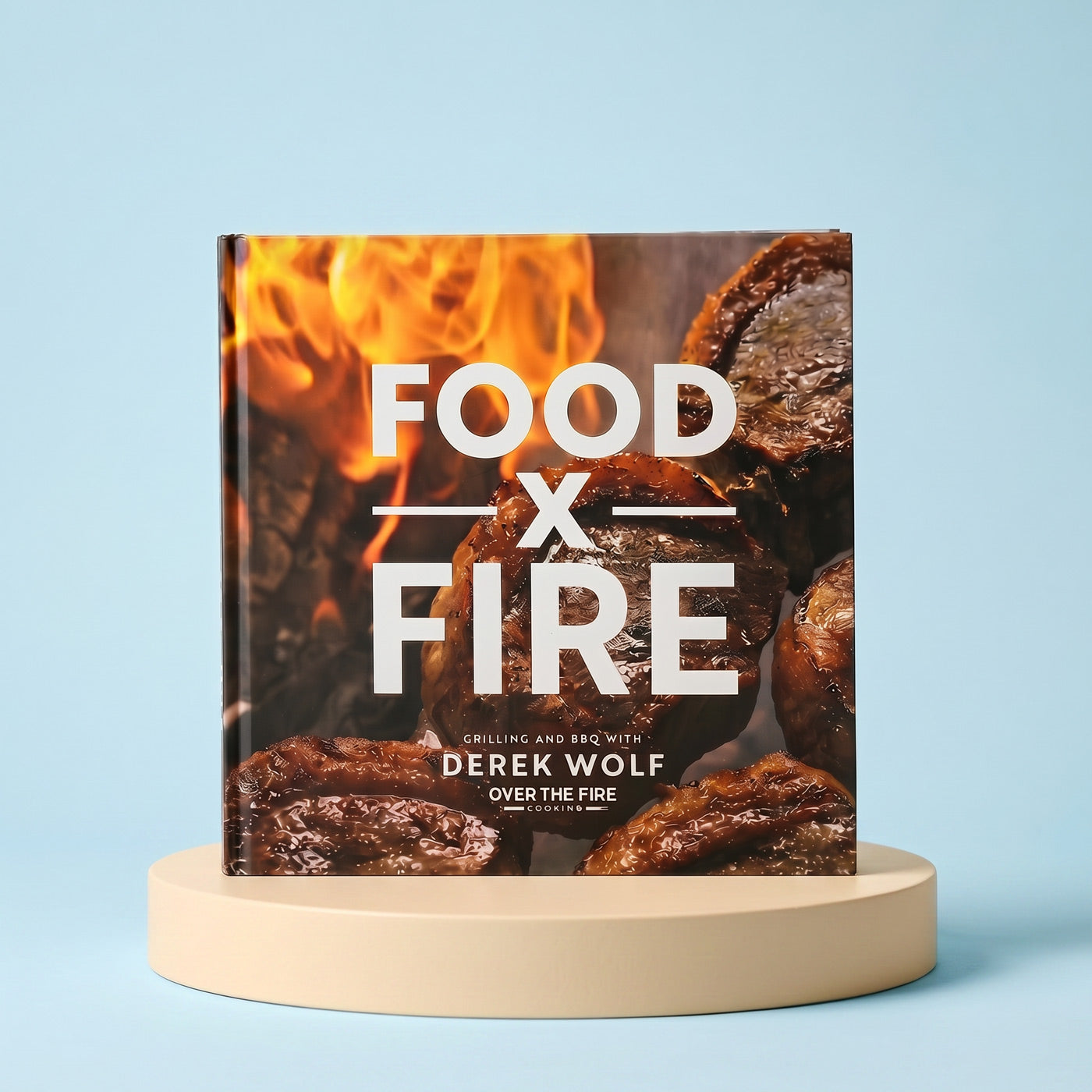 Book titled 'Food x Fire' by Derek Wolf on a light blue background