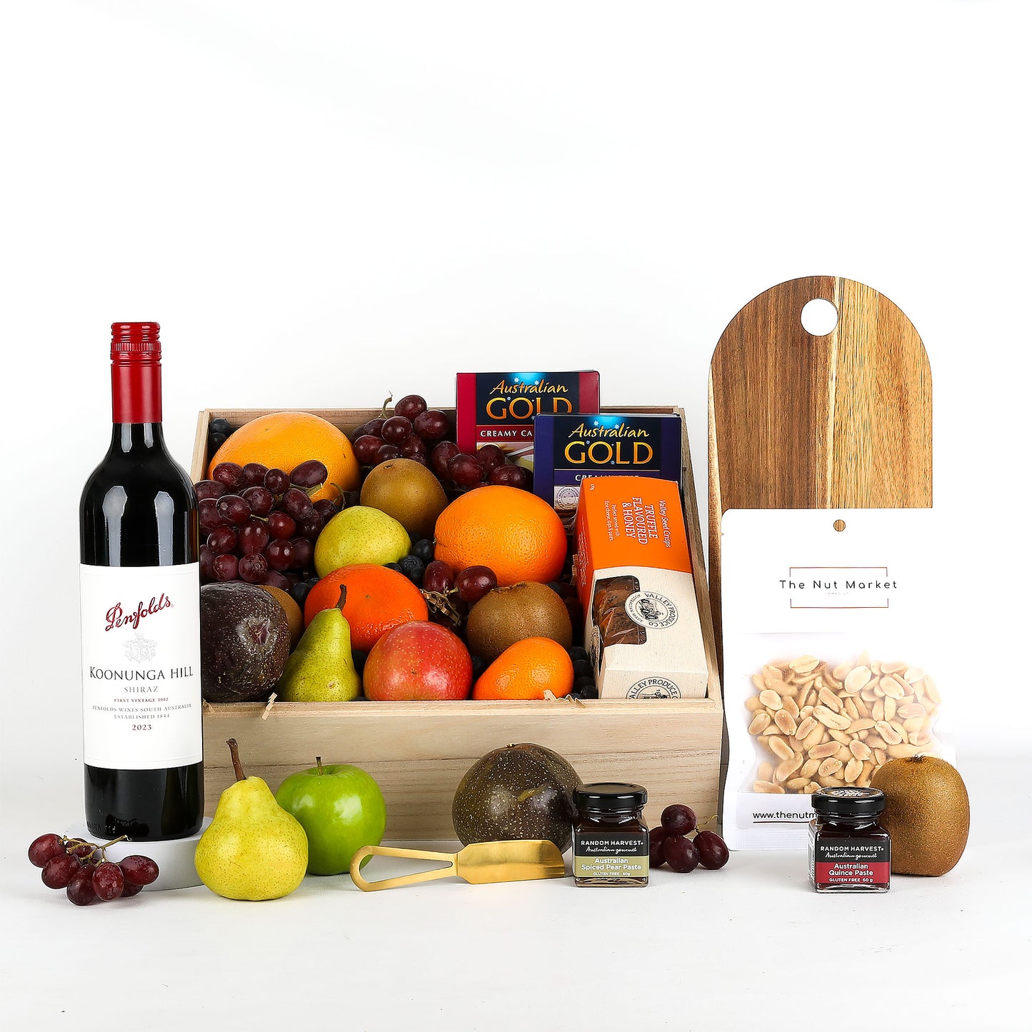 Fruit basket with red wine, treats and cheese board on a white background
