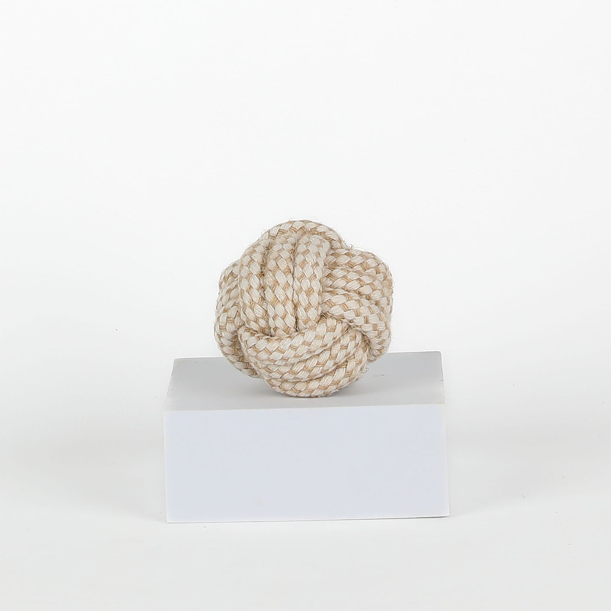 rope toy on a white pedestal against a white background
