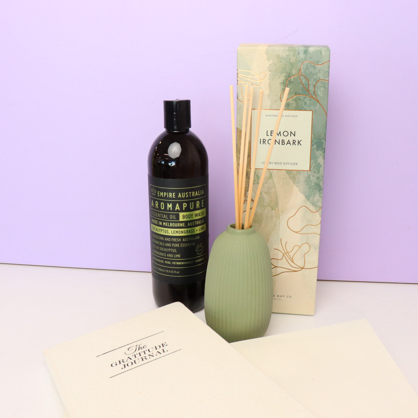Aromatherapy product set with bottle, diffuser, and journal on a light purple background
