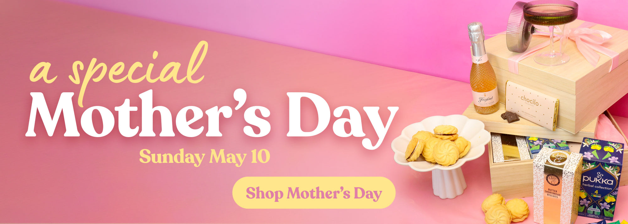 Promotional banner for Mother's Day with gifts, snacks, and a bottle of champagne on a pink background.