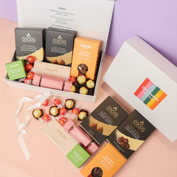 Assorted chocolate bars in a gift box with visible branding on a pastel background