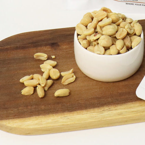 Packages of The Nut Market nuts on a white surface with a blue background