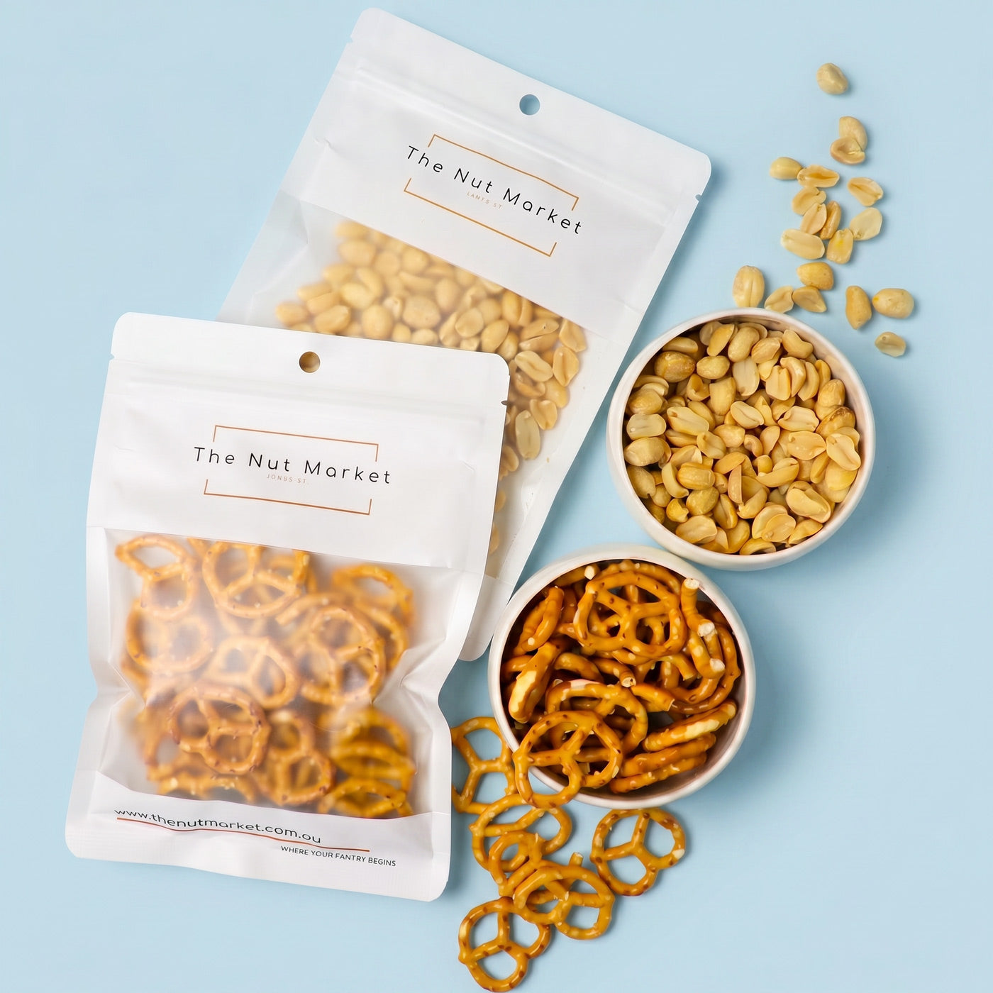 Snack packaging from 'The Nut Market' with pretzels and peanuts on a light blue background