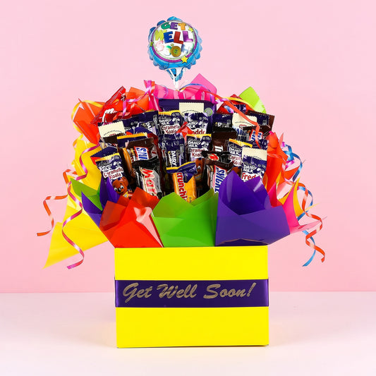 Colorful gift box with candy and 'Get Well Soon!' balloon on pink background