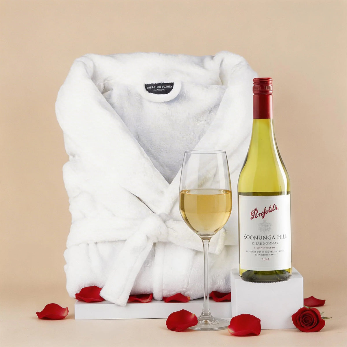 Sheraton luxury white microplush bathrobe with Penfolds Chardonnay wine gift hamper on neutral background