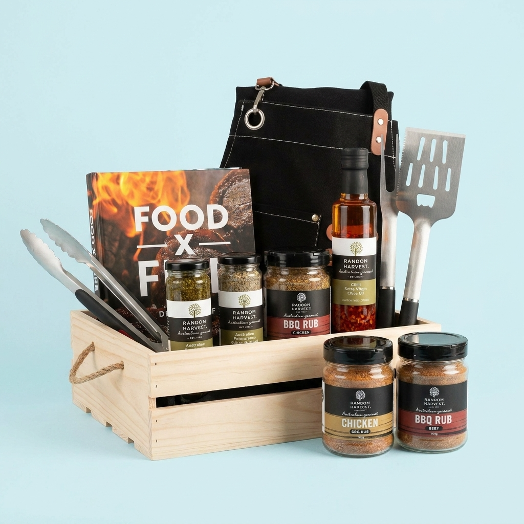 Gourmet gift basket with barbecue items including spices, a cookbook, and utensils on a light blue background.