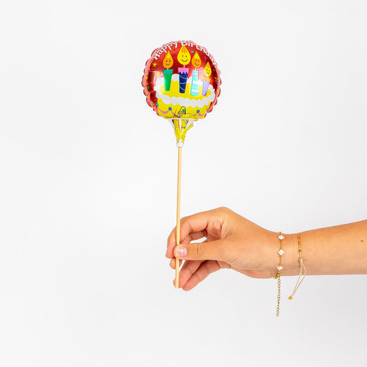 Hand holding a small balloon against a white background