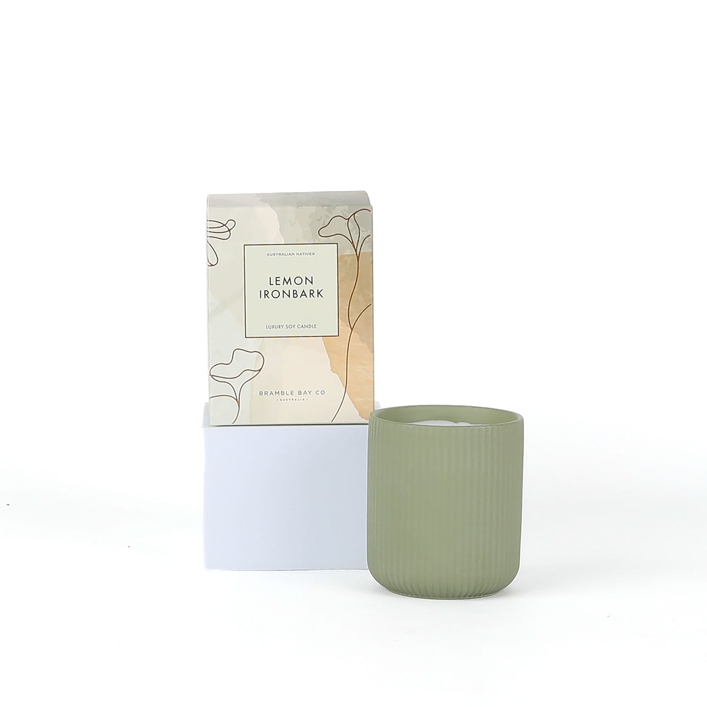 Green candle with packaging labeled 'Lemon Ironbark' on a white background