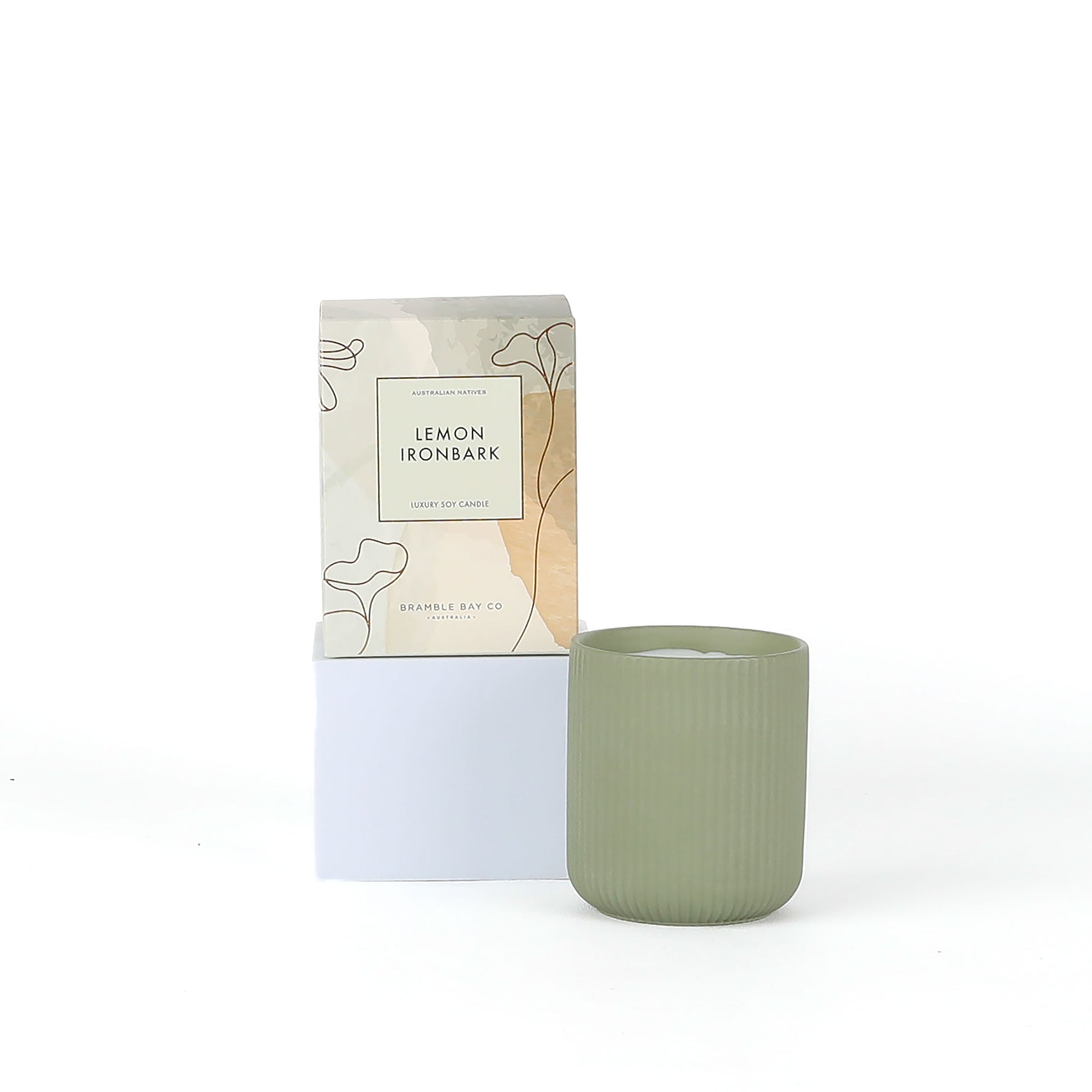 Green candle with packaging labeled 'Lemon Ironbark' on a white background