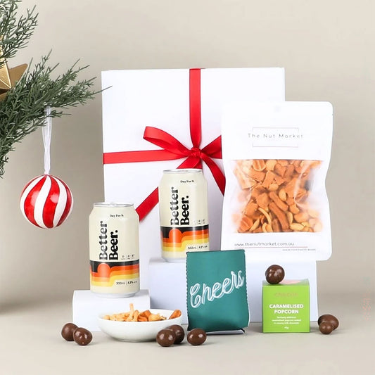 Gift set with two cans of beer, & snacks on a neutral background