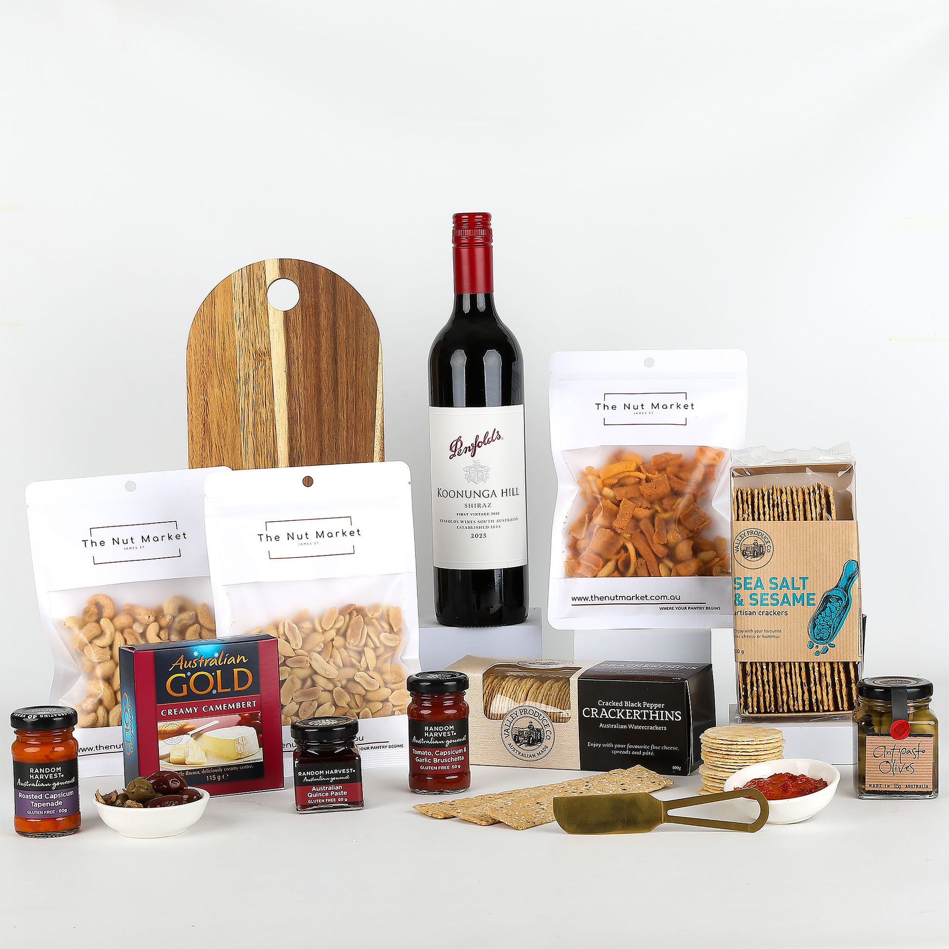 Assorted food items including wine, nuts, spreads & cheese board on a white background