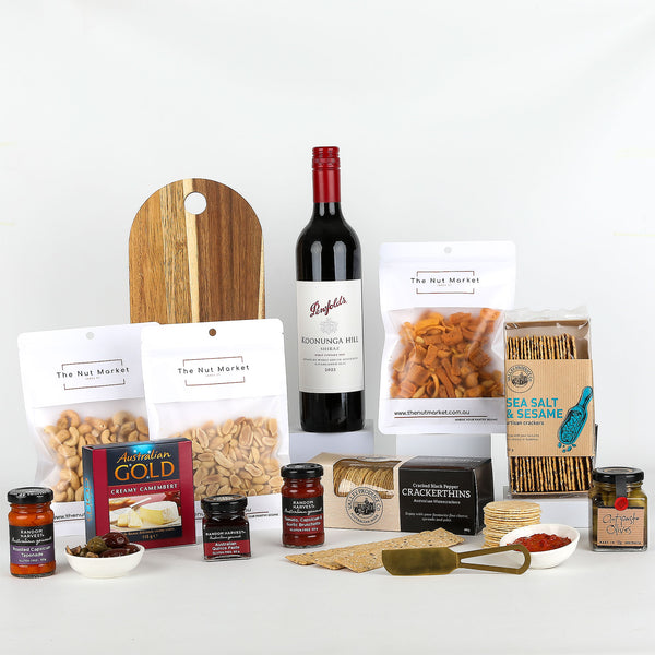 Assorted food items including wine, nuts, spreads & cheese board on a white background