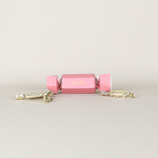 Pink chocolate cracker with gold accents on a light gray background