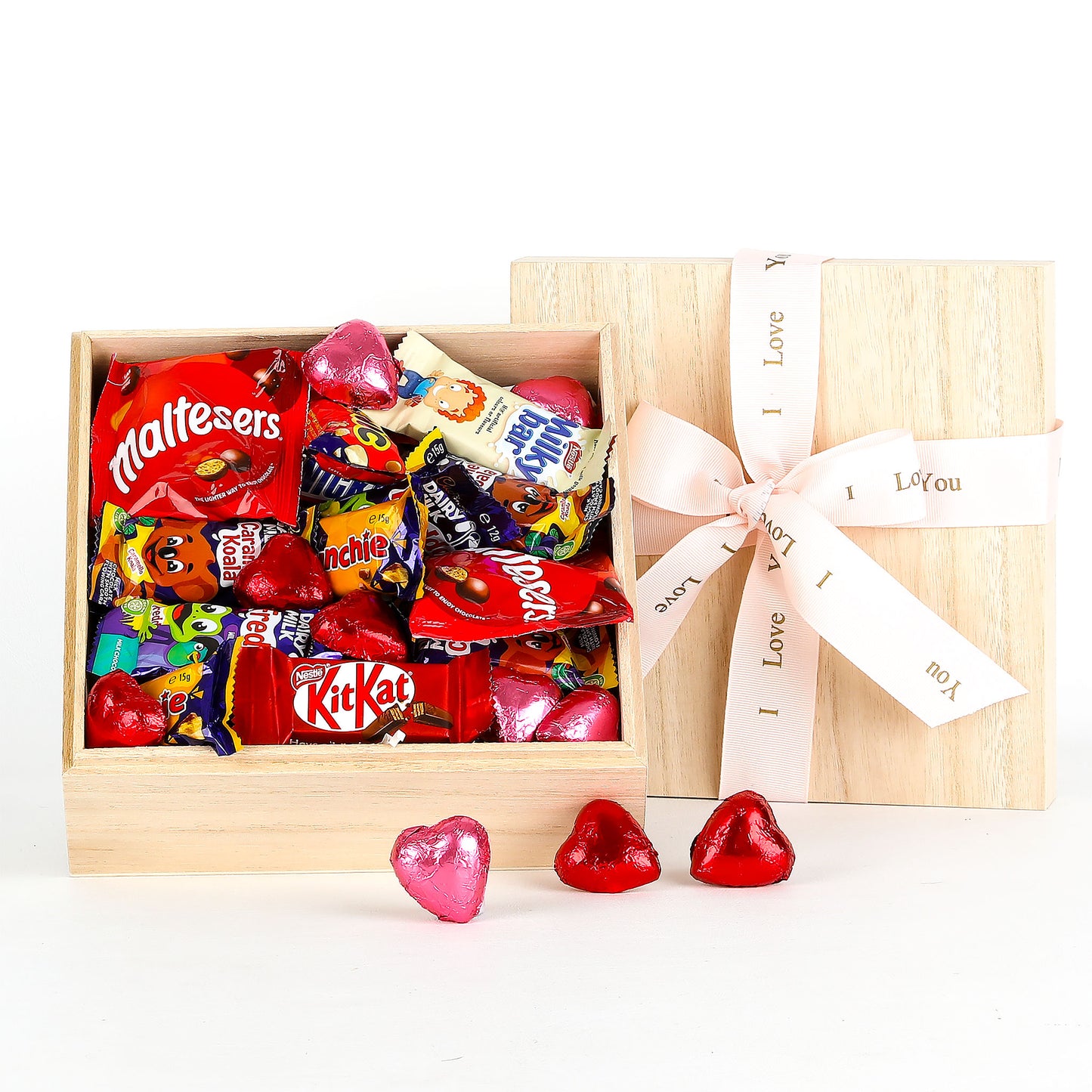 Wooden gift box filled with various chocolates and a 'I Love You' ribbon on a white background.
