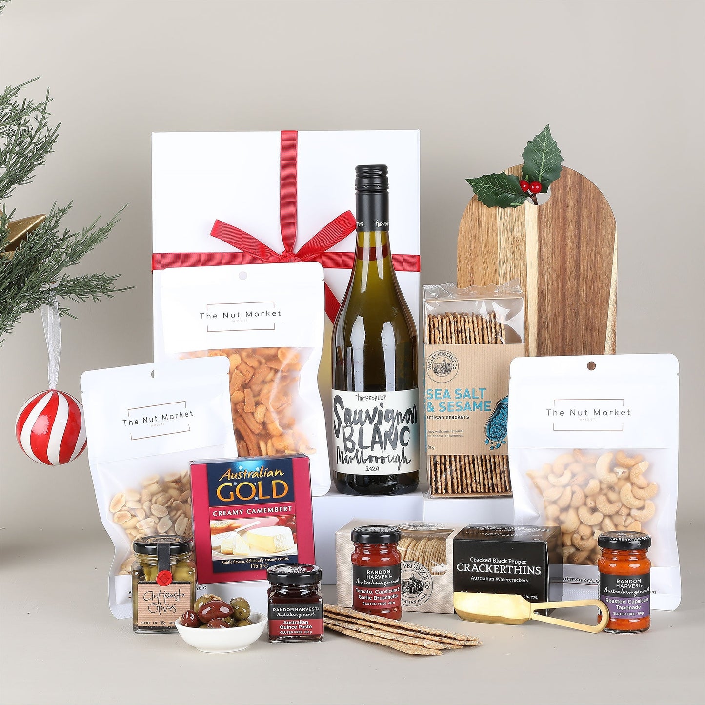 Assorted food items including a bottle of wine, nuts, and condiments on a neutral background.