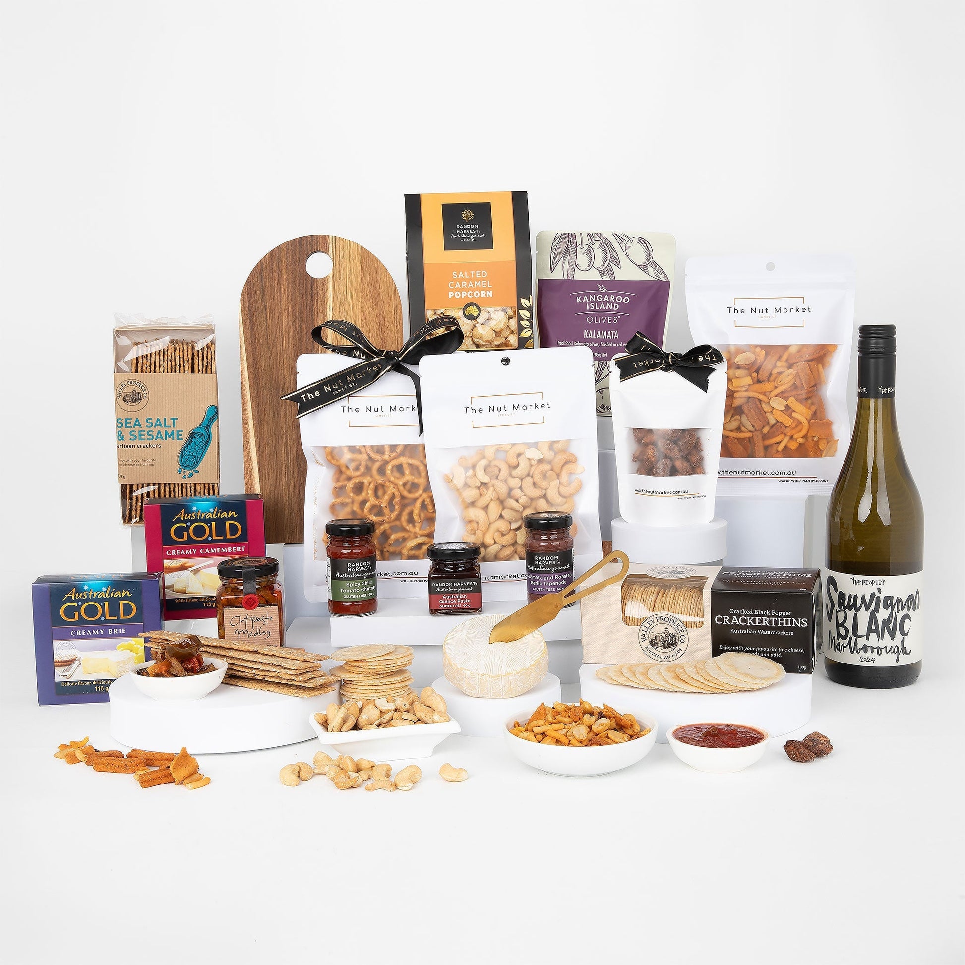 Assorted food products including nuts, spreads, and a bottle of wine on a white background