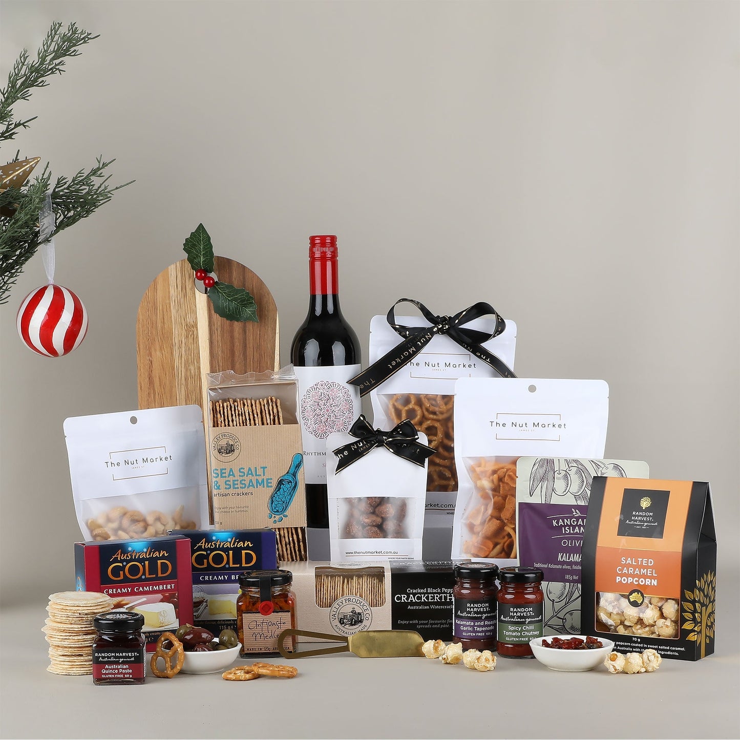 Assorted gourmet food items including wine, snacks, and crackers on a neutral background.