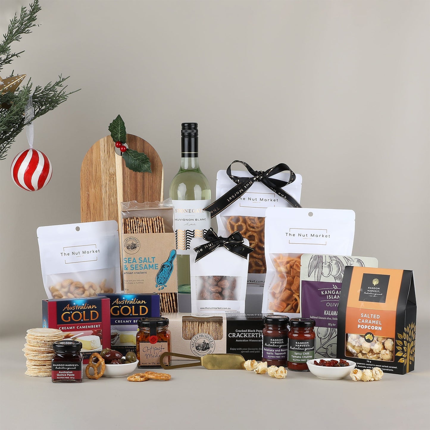 Gourmet gift basket with wine, snacks, and other treats on a neutral background