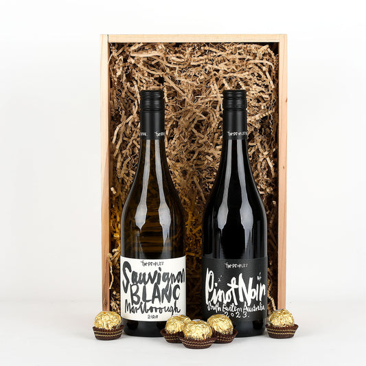 Two bottles of wine in a wooden gift box with gold chocolates on a white background