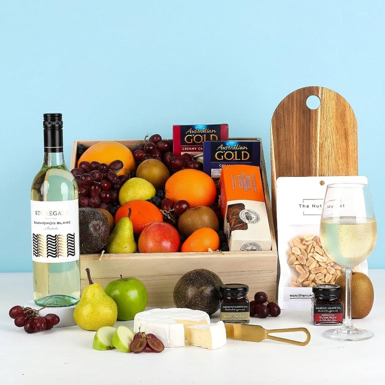 Fruit basket with white wine and nibbles. Fresh fruit and gourmet nibbles 