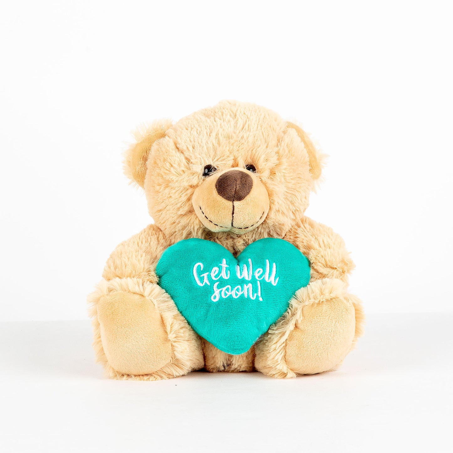 Plush teddy bear holding a teal heart that says, 'Get well soon!' on a white background