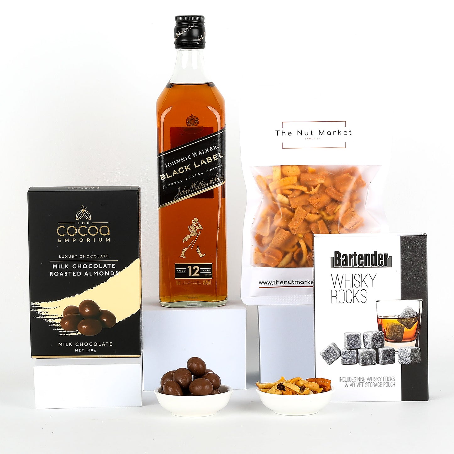 Johnnie Walker Black Label whisky with chocolate, nuts, and whiskey rocks on a white background