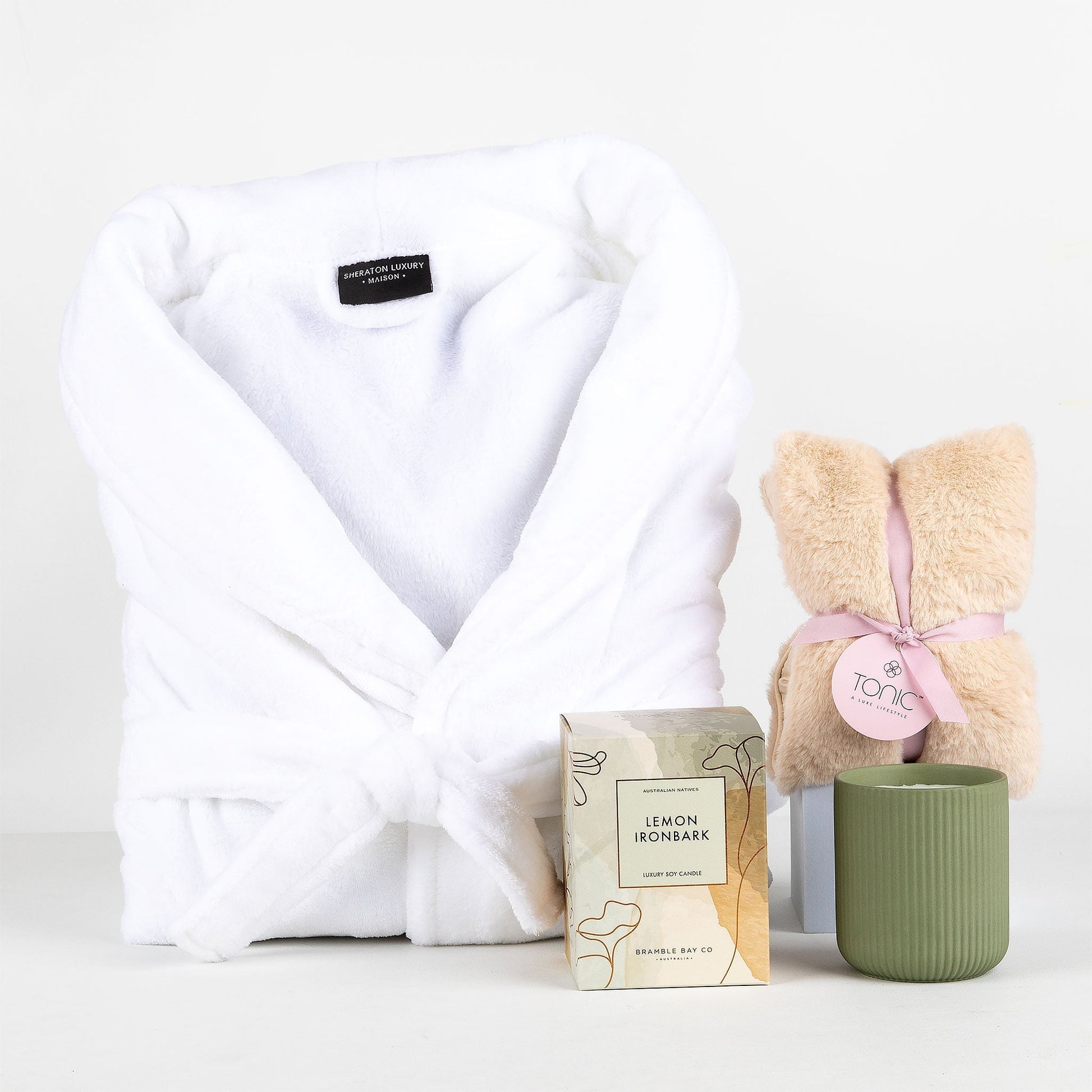 White robe, candle & heat pillow on a white background