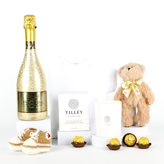 Bottle of Prosecco, teddy bear, and chocolates on a white background