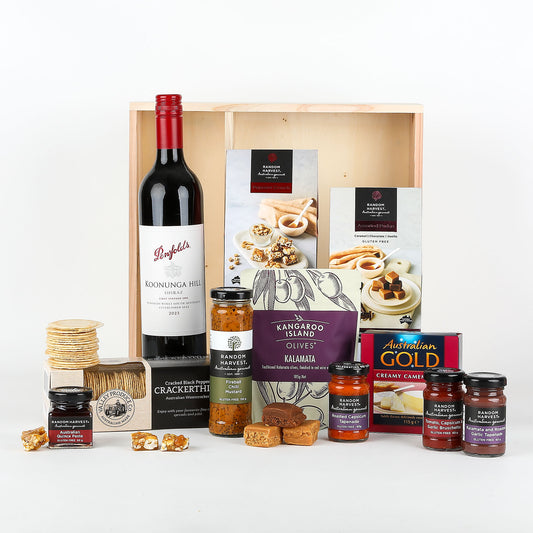 Gourmet gift set with wine, snacks, and jams in a wooden box.