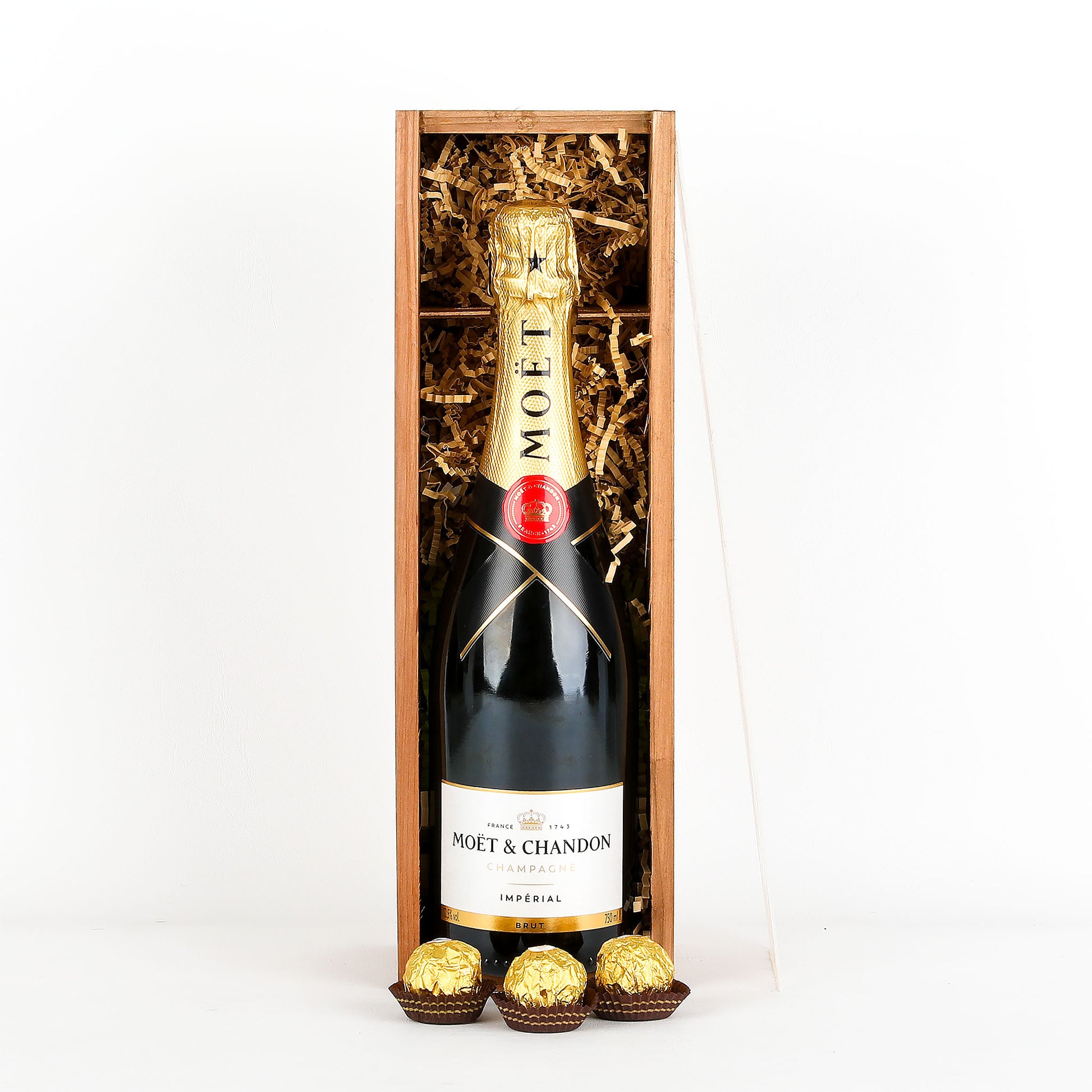 Moët & Chandon champagne bottle in a wooden gift box with chocolates on a white background