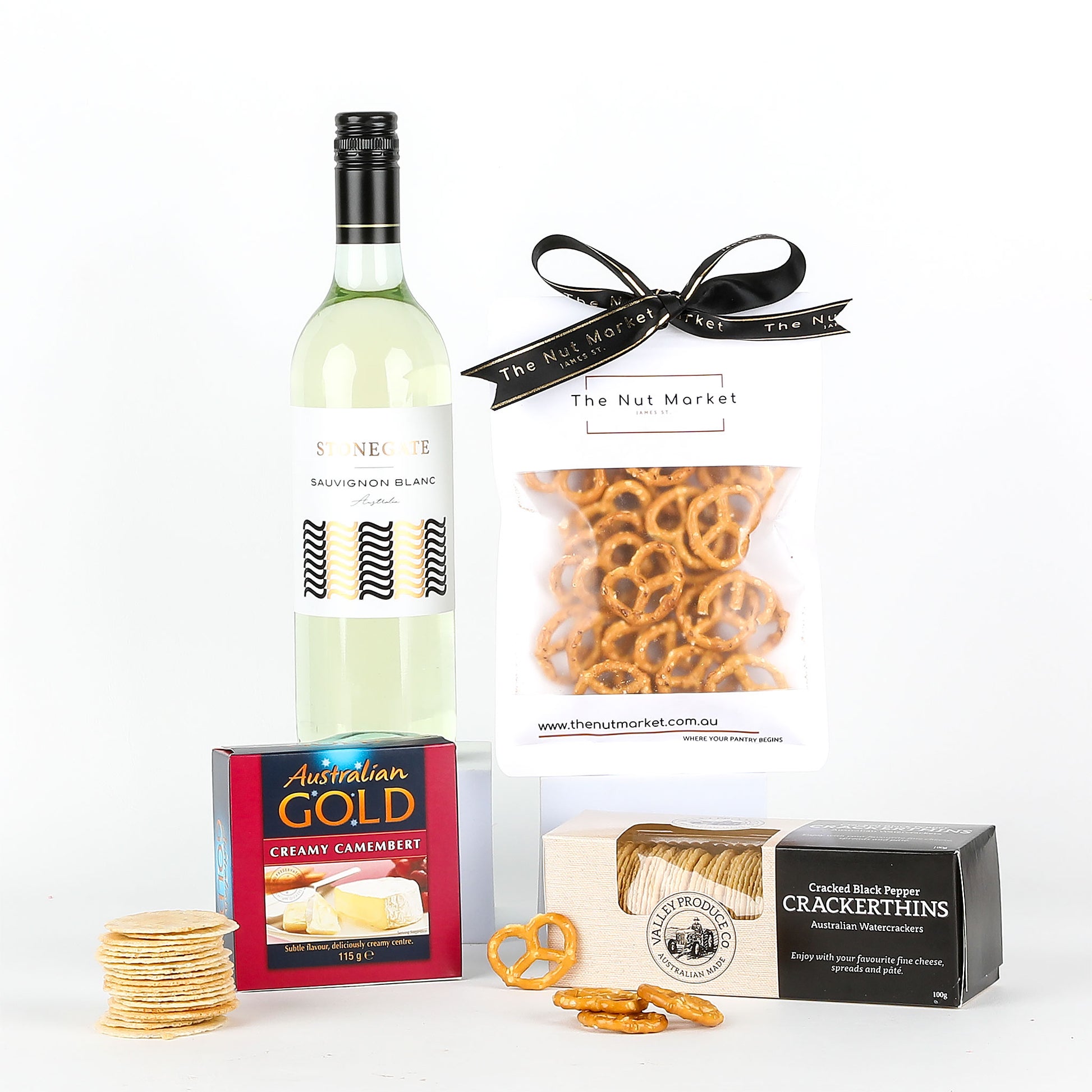 Wine bottle with cheese, crackers, and pretzels on a white background