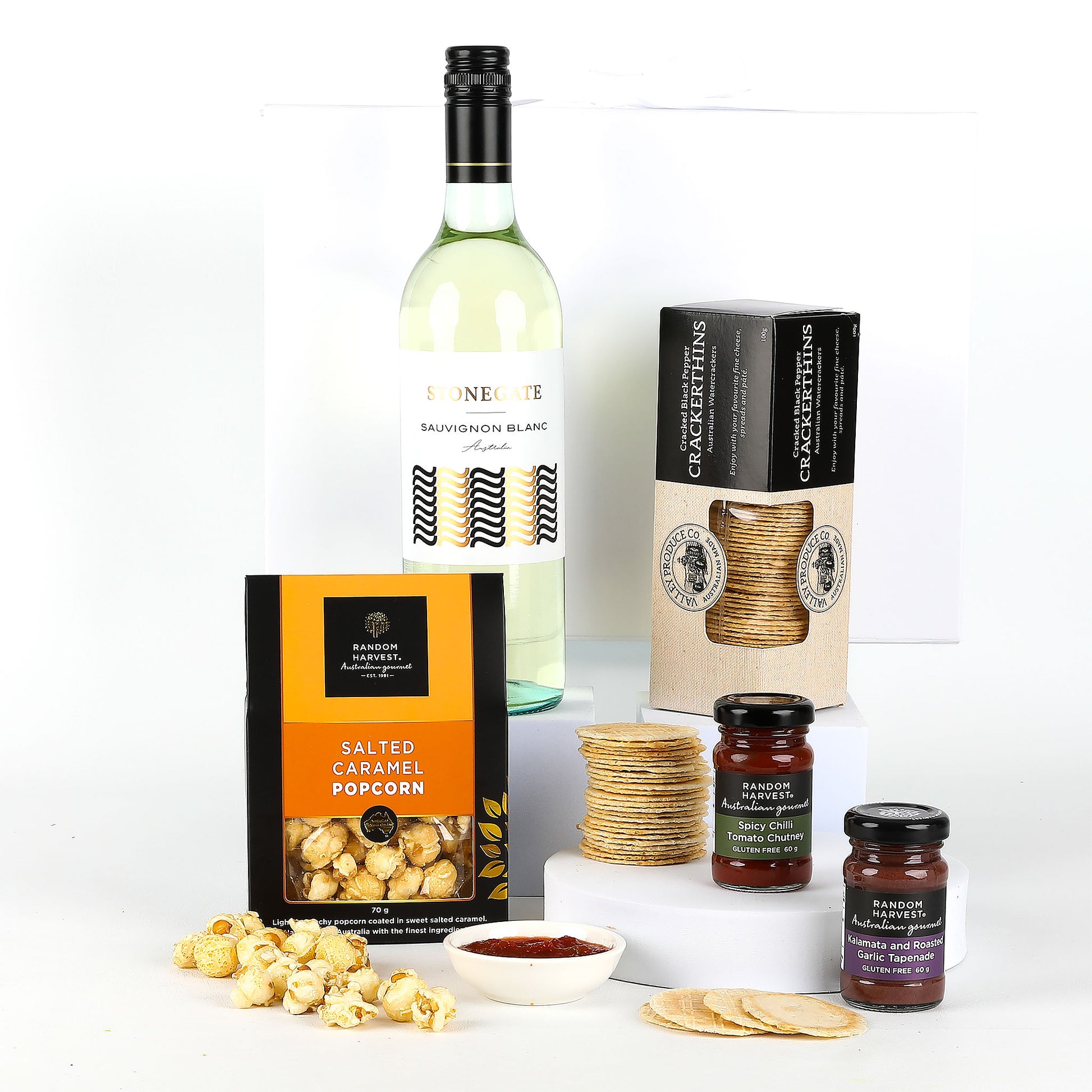 Wine bottle with popcorn, crackers, and snacks on a white background