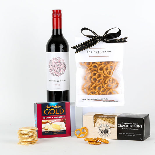 Wine bottle, cheese box, crackers, and pretzels on a white background