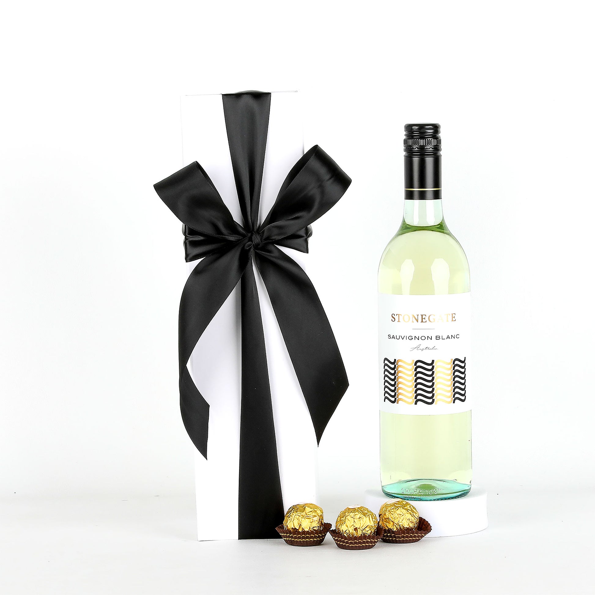 Bottle of white wine with a black ribbon and Ferrero Rocher chocolates on a white background