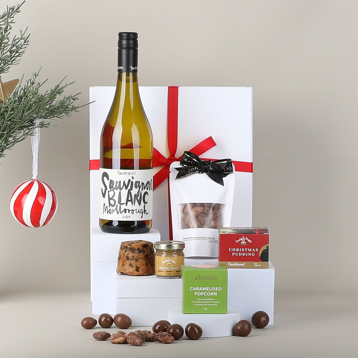 Gift box with a bottle of wine & snacks on a neutral background