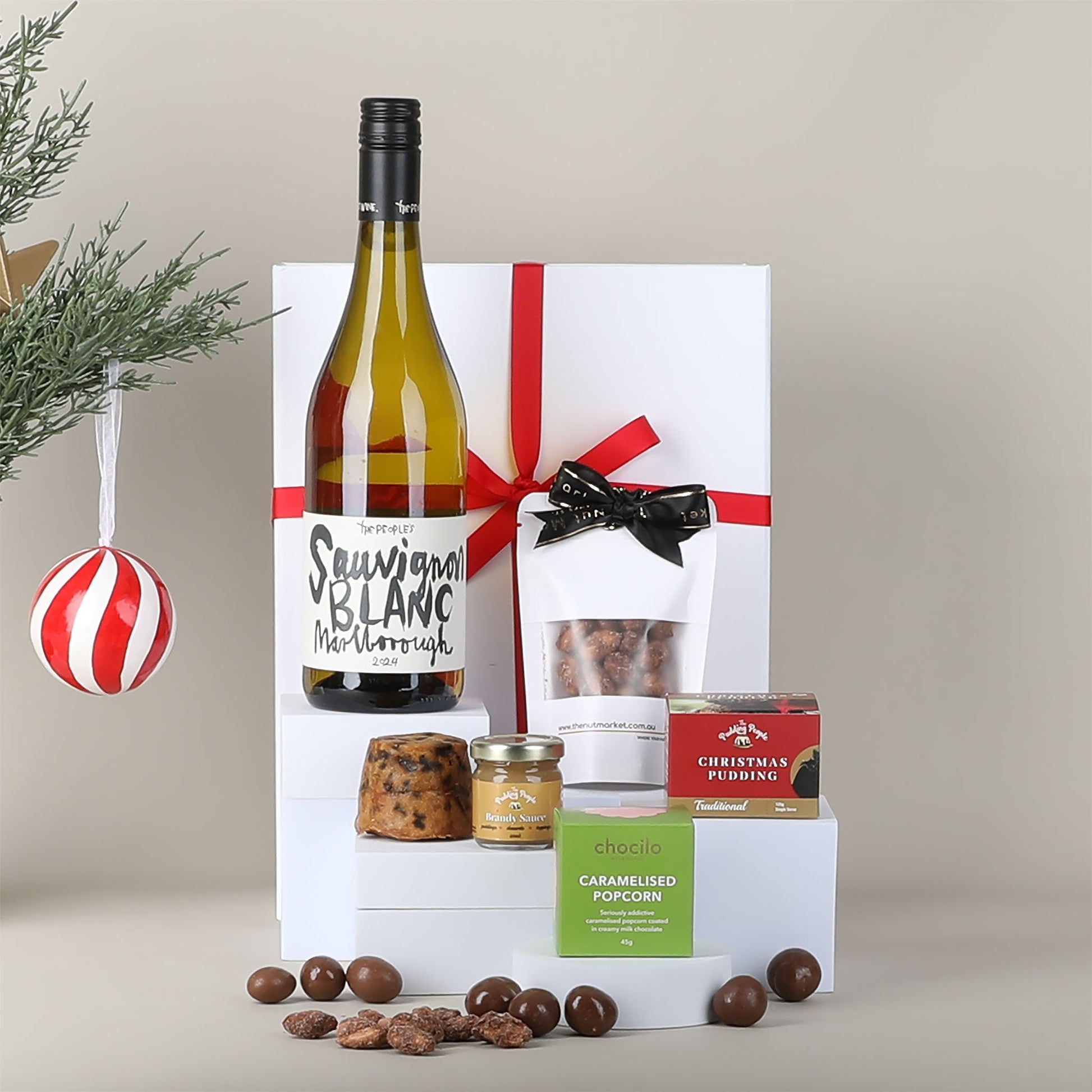 Gift box with a bottle of wine & snacks on a neutral background