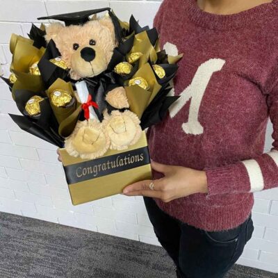 Gift Basket employee holding a Chocolate bouquet with a teddy in the middle. 