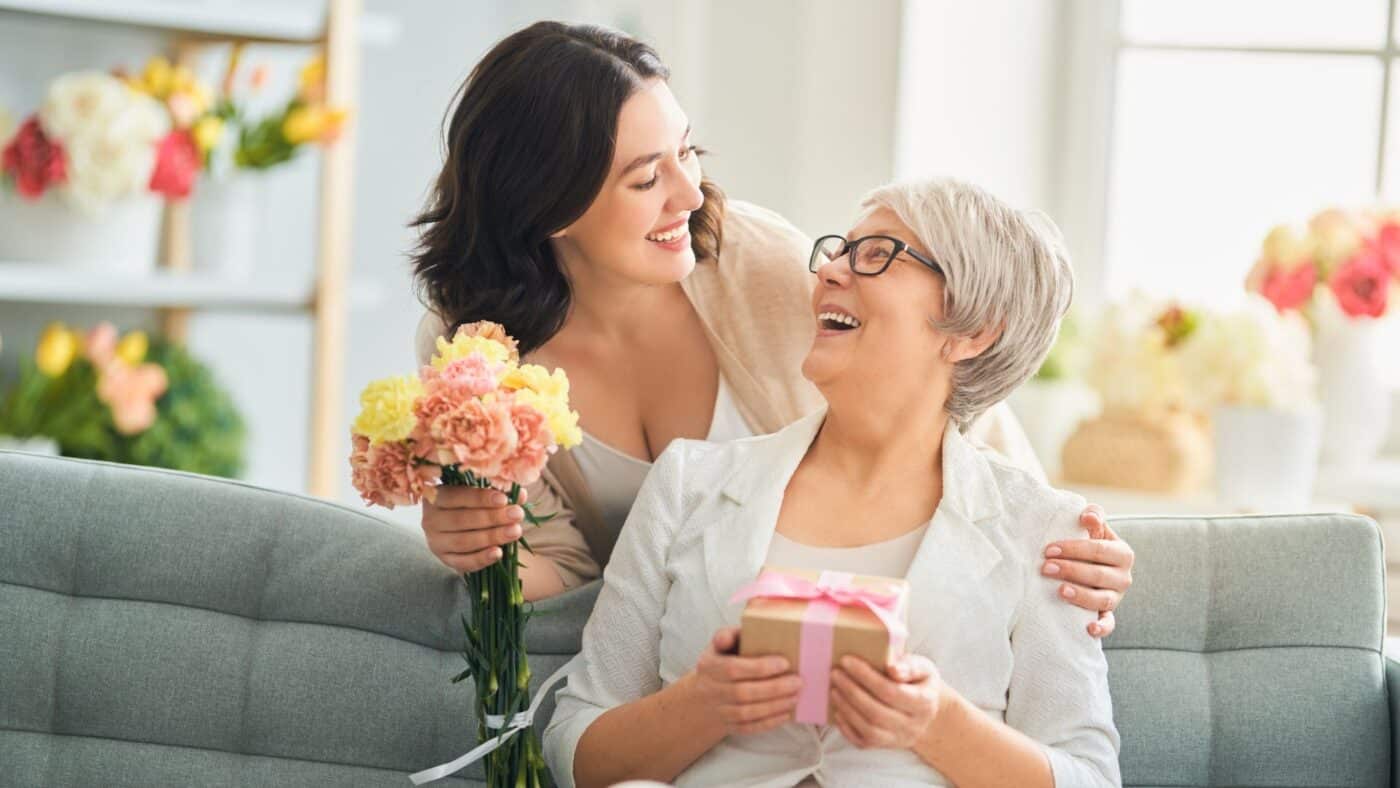 Daughter deliving beautiful mother's day hamper to mum.