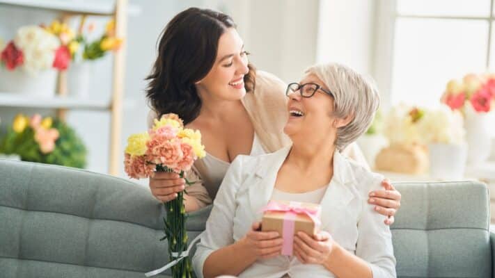 Daughter deliving beautiful mother's day hamper to mum.